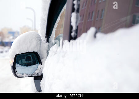 Closeup Schnee Fenster und Rückspiegel der grauen Minibus Auto. Konzept, Schnee, Schneefall, schlecht nördlichen Wetterbedingungen, low battery, se Stockfoto