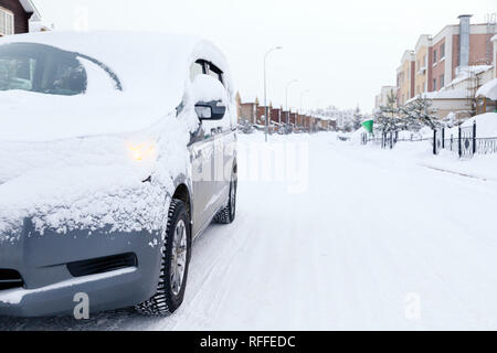 Closeup grau Minibus schmutziges Auto mit Schnee auf der Stadt abgedeckt. Vorderansicht. Konzept, Schnee, Schneefall, schlecht nördlichen Wetterbedingungen, niedrig Stockfoto