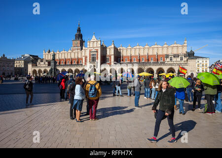 Stadt Krakau in Polen, Gruppe von Menschen, die Touristen am Hauptplatz in der Altstadt, Tuchhallen (Sukiennice) im Hintergrund. Stockfoto