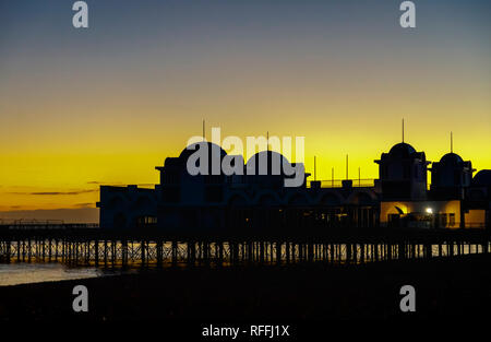 Viktorianische Struktur, South Parade Pier in Silhouette und der Strand Küste bei Sonnenuntergang in Southsea, Portsmouth, Hampshire, Südengland bei Dämmerung Stockfoto