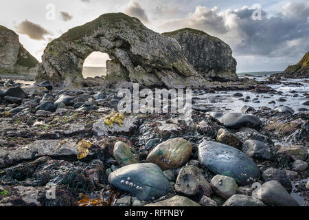 Dies ist das Meer arch in ballintoy an der Nordküste von Irland. Dies war bei Ebbe verlassen Tide Pools der Himmel widerspiegelt, Stockfoto