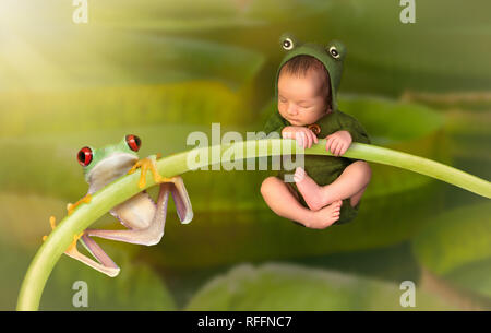 7 Tage alten kleinen neugeborenen Baby gekleidet wie ein grüner Baum Frosch auf einem Zweig zusammen hängen mit einem echten Red Eyed Tree Frog Stockfoto