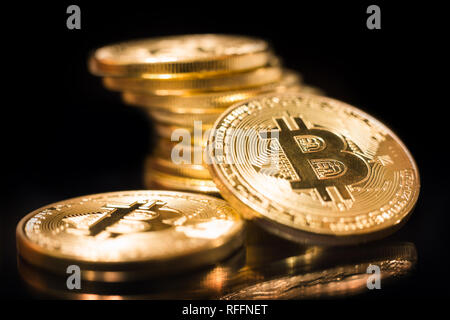 Stapel von Bitcoins auf glänzenden schwarzen Oberfläche reflektiert und Schwarz im Hintergrund Stockfoto