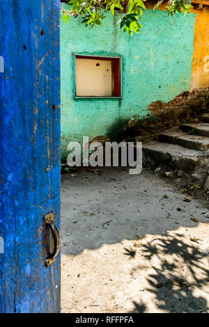 Öffnen Sie im Landhausstil blau lackierte Tür & Türkis & gelbes Gebäude Wand mit Verbrettert Fenster in Guatemala, Mittelamerika Stockfoto
