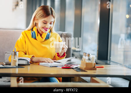 Frau sah in ihre täglichen Planer in der Cafeteria sitzen Stockfoto
