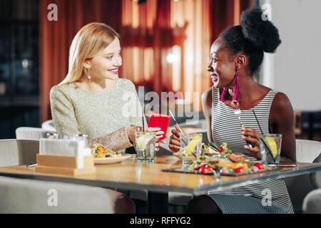 Zwei stilvolle freundliche Frauen, schöne Kleider mit Mittagessen Stockfoto