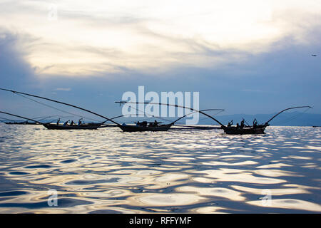 Traditionelle Fischerboote am Kivusee mit Reflexion der Sonne auf dem Wasser. Ruanda, Ost Afrika. Stockfoto