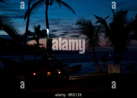 Ein Foto von einem Parkplatz am Strand bei einem schönen Sonnenuntergang. Vor dem Hintergrund der schönen Palmen und karibischen Meer. Stockfoto