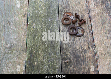 Verwitterte Palette Holz Bretter senkrecht als Hintergrund mit rostigen Schrauben, Muttern und Unterlegscheiben ausgerichtet, in der rechten oberen Ecke platziert. Stockfoto