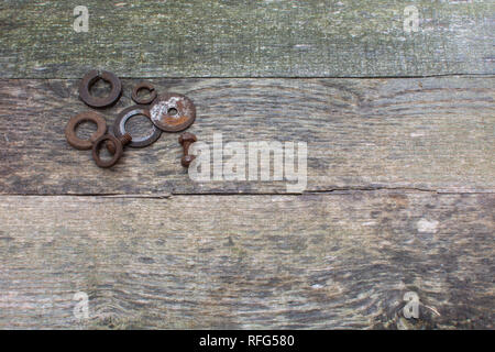 Verwitterte Palette Holz Bretter als Hintergrund mit rostigen Unterlegscheiben und Schrauben in der oberen linken Ecke platziert. Stockfoto