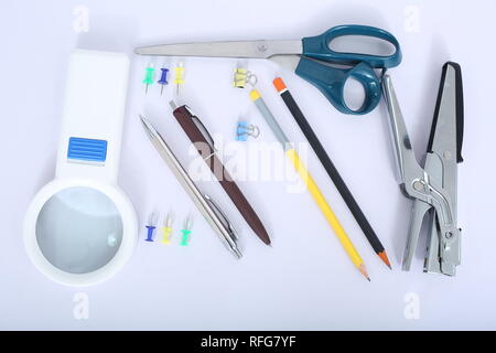 Bild von Kugelschreiber, Hefter, Bleistift, Schere, Papier Clip und Lupe. Stockfoto