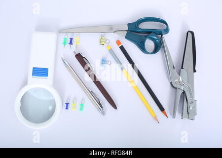 Portrait von Kugelschreiber, Hefter, Bleistift, Schere, Papier Clip und Lupe. Stockfoto