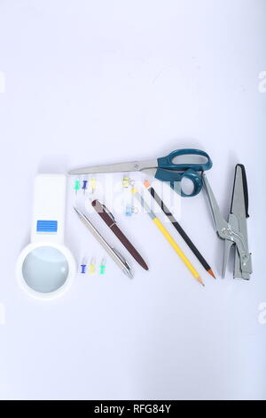 Blick von oben auf die Kugelschreiber, Hefter, Bleistift, Schere, Papier Clip und Lupe. Stockfoto