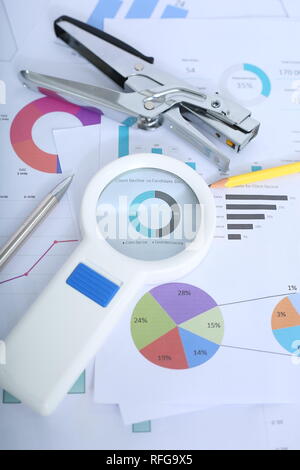 Portrait von Pen, Hefter, Bleistift und Lupe auf der finanziellen Papier. Stockfoto