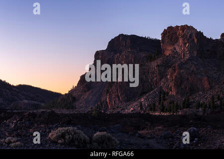 Erste Sonnenstrahlen Sonnenaufgang sun Beleuchtung einer Felswand auf der Caldera rim in der Las Canadas del Teide National Park, Teneriffa, Kanarische Inseln, Spanien Stockfoto