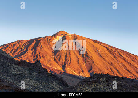 Mount Teide erleuchtet von den ersten Strahlen der Sonne in der Dämmerung rot glühenden gegen ein strahlend blauer Himmel in der Las Canadas del Teide National Park, Teneriffa, Kanarische Inseln Stockfoto