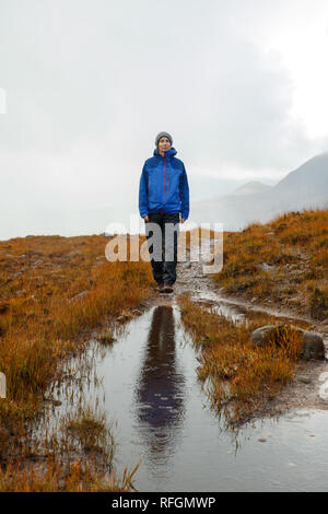 Eine Person, die in der schottischen Landschaft in der Nähe des Allt Bottighofen Rooill Fluss in Torridon, Schottland Stockfoto