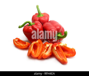 Stillleben mit drei ganze und aufgeschnittene rote reife Paprika auf weißem Hintergrund closeup isoliert Stockfoto