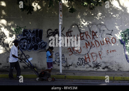Valencia, Carabobo, Venezuela. Januar 25, 2019. 25 Jan, 2019. Die Bewohner vor einer Wand mit Graffiti gegen die Ablehnung von Nicolas Maduro, das Wort ''Maduro Out'' gelesen wird auf verschiedenen Wände verschiedener Städte im Land, die Fotos in der Stadt Valencia, Carabobo Zustand und entsprechen. Foto: Juan Carlos Hernandez Credit: Juan Carlos Hernandez/ZUMA Draht/Alamy leben Nachrichten Stockfoto
