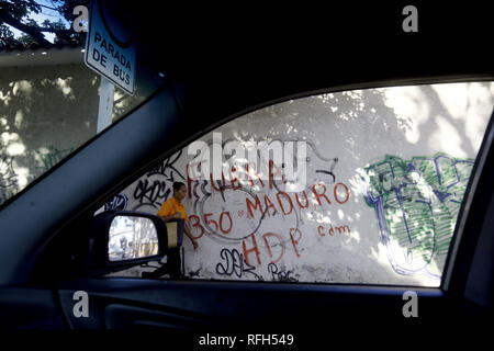 Valencia, Carabobo, Venezuela. Januar 25, 2019. 25 Jan, 2019. Die Bewohner vor einer Wand mit Graffiti gegen die Ablehnung von Nicolas Maduro, das Wort ''Maduro Out'' gelesen wird auf verschiedenen Wände verschiedener Städte im Land, die Fotos in der Stadt Valencia, Carabobo Zustand und entsprechen. Foto: Juan Carlos Hernandez Credit: Juan Carlos Hernandez/ZUMA Draht/Alamy leben Nachrichten Stockfoto