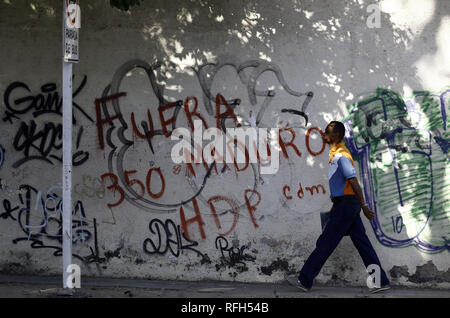 Valencia, Carabobo, Venezuela. Januar 25, 2019. 25 Jan, 2019. Die Bewohner vor einer Wand mit Graffiti gegen die Ablehnung von Nicolas Maduro, das Wort ''Maduro Out'' gelesen wird auf verschiedenen Wände verschiedener Städte im Land, die Fotos in der Stadt Valencia, Carabobo Zustand und entsprechen. Foto: Juan Carlos Hernandez Credit: Juan Carlos Hernandez/ZUMA Draht/Alamy leben Nachrichten Stockfoto