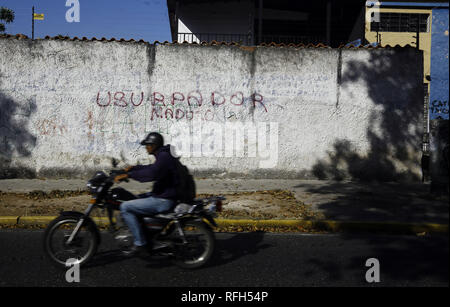 Valencia, Carabobo, Venezuela. Januar 25, 2019. 25 Jan, 2019. Die Bewohner vor einer Wand mit Graffiti gegen die Ablehnung von Nicolas Maduro, das Wort ''Maduro Usurpator'' auf verschiedenen Wände in verschiedenen Städten des Landes gelesen wird, die Fotos in der Stadt Valencia, Carabobo Zustand und entsprechen. Foto: Juan Carlos Hernandez Credit: Juan Carlos Hernandez/ZUMA Draht/Alamy leben Nachrichten Stockfoto