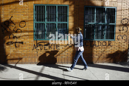 Valencia, Carabobo, Venezuela. Januar 25, 2019. 25 Jan, 2019. Die Bewohner vor einer Wand mit Graffiti gegen die Ablehnung von Nicolas Maduro, das Wort 'Tod dem Diktator'' 'und auf verschiedenen Wände in verschiedenen Städten des Landes gelesen wird, die Fotos in der Stadt Valencia, Carabobo Zustand entsprechen. Foto: Juan Carlos Hernandez Credit: Juan Carlos Hernandez/ZUMA Draht/Alamy leben Nachrichten Stockfoto