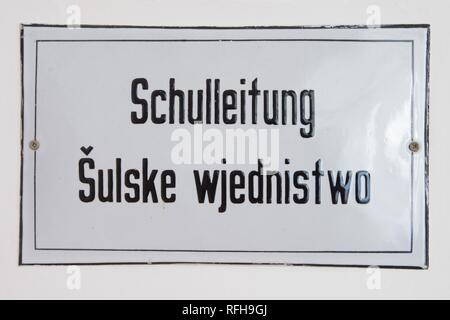 25 Januar 2019, Sachsen, Räckelwitz: Das Wort 'Schulleitung' ist in Deutsch und Sorbisch geschrieben wurde, auf einem Emaille Schild in der sorbischen Oberschule Räckelwitz. Foto: Sebastian Kahnert/dpa-Zentralbild/dpa Stockfoto