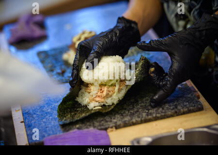 Berlin, Deutschland. 26 Jan, 2019. Ein Mitarbeiter bereitet sich ein Burger von Reis, Nori Blätter und Lachs für die Besucher am Japan Festival in der Urania. Credit: Gregor Fischer/dpa/Alamy leben Nachrichten Stockfoto