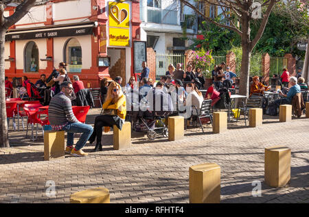 Kunden, die die Wintersonne vor der Tapas-Bar Arte y Solera in Sevilla, Spanien, genießen Stockfoto