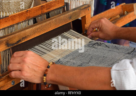 Close up Mann Hände Webart Leinwand mit antiken Webstuhl handweave Maschine, Seitenansicht Stockfoto