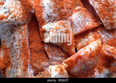 Viele Rohstoffe saftig geschnitten frische Fischfilets rosa Stück gut mit rotem Pfeffer bestreut, bereit sind, für das Backen Top View closeup Stockfoto