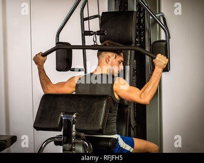 Muskulöser junger Mann, Training pecs auf Fitnessgerät Stockfoto