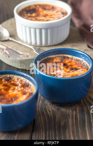 Crème Brûlée in den Töpfen auf dem Holzbrett Stockfoto