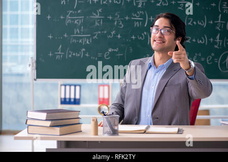 Junge schöne Mathematik Lehrer im Klassenzimmer Stockfoto