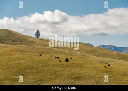 Das Assy Turgen Informationsstelle erhebt sich über eine Herde Pferde grasen in großer Höhe auf der Zsb Plateau, Kasachstan Stockfoto