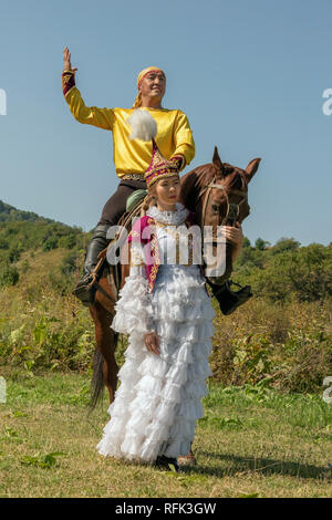 Kasachischen der Mann und die Frau in der traditionellen Kleidung mit Pferd, Almaty, Kasachstan Stockfoto