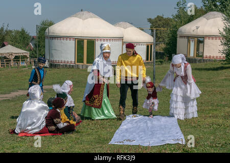"Tusau Kesu' Zeremonie (schneiden Sie das Seil) Der erste Schritt mit der Familie in festliche Kleidung, Almaty, Kasachstan. Stockfoto