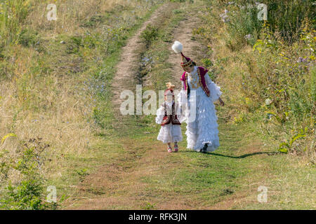 Mutter und Tochter in festlicher Kleidung bergab wandern, Almaty, Kasachstan Stockfoto
