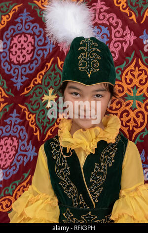 Porträt einer kasachischen Mädchen gegen eine gefilzte Teppich in einer Jurte, Alamty, Kasachstan Stockfoto