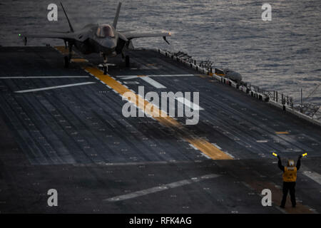 Die US-Marine Aviation Bootsmann mate zugeordnet zu den amphibischen Angriff Schiff USS Wasp (LHD 1) meldet eine F-35B Blitz II Flugzeuge mit Marine Fighter Attack Squadron (Vmfa) 121 während des Flugbetriebs während im Ostchinesischen Meer, Jan. 24, 2019 im Gange. Der Luftfahrt Bootsmann Gehilfen tragen unverwechselbar, leuchtend gelben T-Shirts und eine Vielzahl von Hand- und Arm-Signale mit Naval aviators und Deck Crew während des Flugbetriebs zu kommunizieren. Marine Medium Tiltrotor Squadron (VMM) 262 (verstärkt) und VMFA-121 umfassen die Luftfahrt Combat Element für die 31 Marine Expeditionary Unit (MEU). Seine na Stockfoto