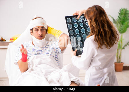 Junger Arzt untersuchen verletzte Patienten Stockfoto