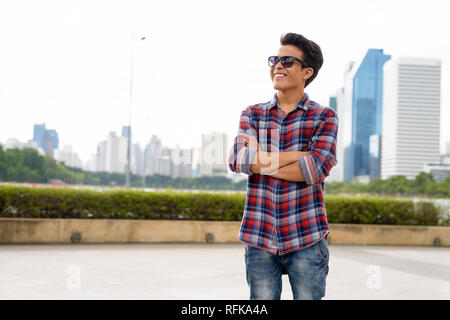 Junge asiatischer Mann Sonnenbrille tragen, während sie sich im Park Stockfoto