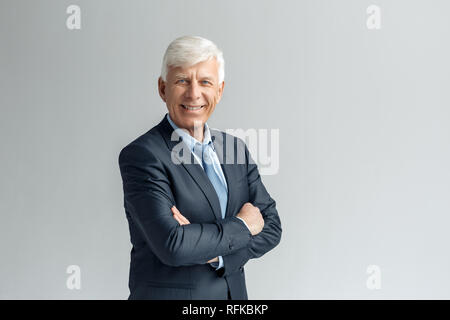 Business Lifestyle. Unternehmer stehen isoliert auf Grau verschränkte Arme lächelte zuversichtlich Stockfoto