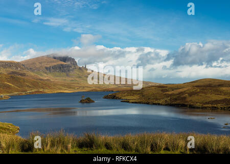 Alte Mann der Storr in Wolken wie aus der Ferne mit Blau klar Loch Leathan an einem sonnigen Herbsttag (Isle of Skye, Schottland, Europa) Stockfoto