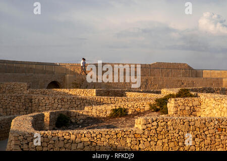 Zwei junge Männer zu Fuß entlang der nördlichen Stadtmauer der Zitadelle in Victoria, Gozo, Malta. Stockfoto