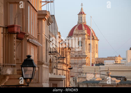 Die Häuserfassaden It-Telgha tal-Riemen Straße vor der Zitadelle mit St George's Basilika im Hintergrund. Stockfoto