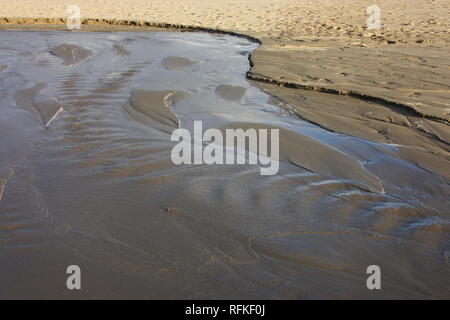 Strom von Wasser oder Verlust von Wasser am Strand des Meeres. torrent oder Stream. Pfütze oder Teich Stockfoto