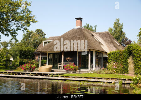 Das reetgedeckte Haus mit schönen Garten in märchenhaften Dorf Giethoorn in den Niederlanden. Stockfoto