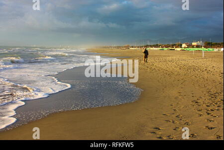 Die Einsamkeit der ein Mann alleine auf eine desolate Winter Strand Stockfoto
